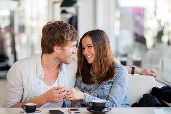 Candid image of young couple smiling in a coffee shop