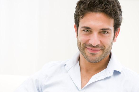 Close up of satisfied smiling Taurus guy looking at camera at home