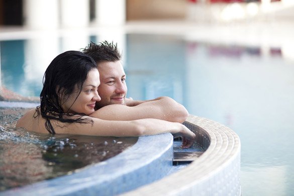 Couple relaxing in jacuzzi of spa center