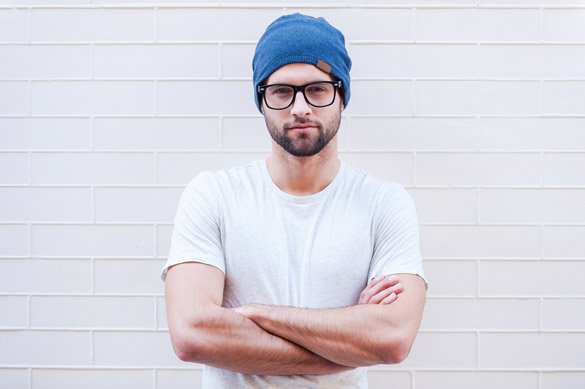 Handsome young Taurus man in eyeglasses keeping arms crossed and looking at camera