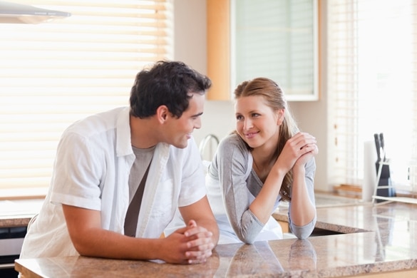 Young couple in the kitchen looking at each other