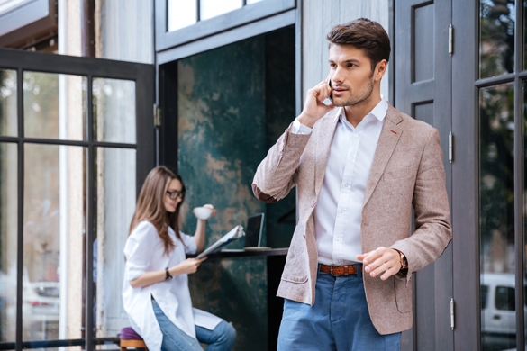 attractive-young-stylish-businessman-talking-on-the-mobile-phone-outdoors-at-the-cafe