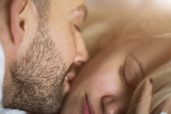 Close-up portrait of a beautiful young kissing couple in bed at home - Taurus Man In Bed With Gemini Woman