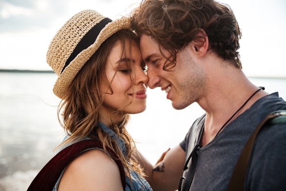 Close up portrait of happy young couple in love embracing each other on beach - How To Cheer Up Your Taurus Guy