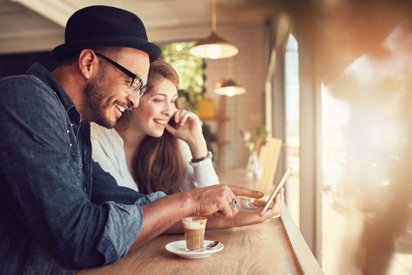 Smiling young couple in a coffee shop using touch screen computer - Taurus Man And Libra Woman Breakup