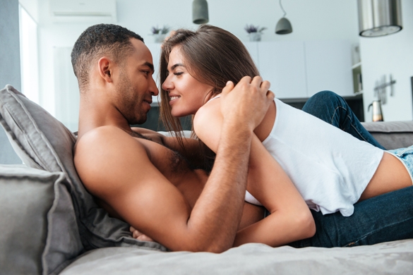 Tender young couple lying and hugging on couch at home - Taurus Man In Bed With Taurus Woman