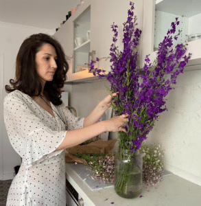 Anna Kovach astrologer looking at the flowers in the kitchen